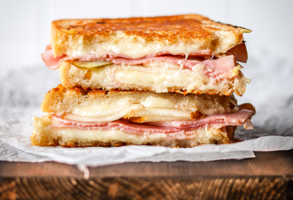 Prosciutto and pear grilled cheese sandwich on chopping board