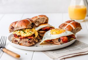 hot cross bun breakfast sandwich on a plate