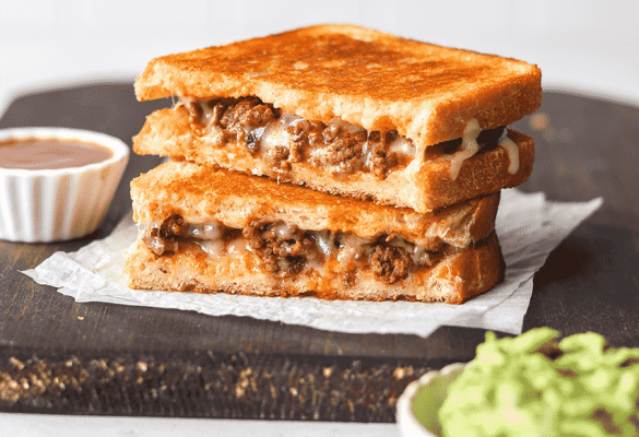 Taco Grilled Cheese on Cutting Board with ketchup and guacamole